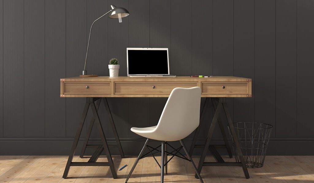 Wooden desk and modern chair against a gray wall