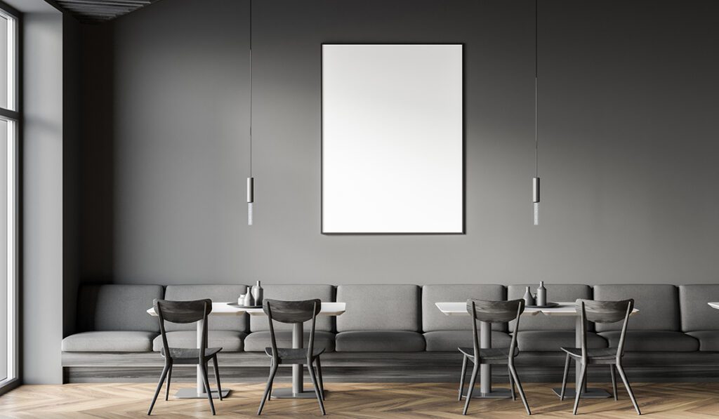 Interior of loft cafe with gray walls, wooden floor, square tables and long gray sofa. Vertical mock up poster. 3d rendering