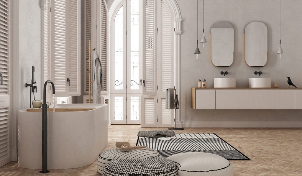 Contemporary bathroom in white tones in vintage apartment with arched window. Freestanding bathtub, washbasins and mirrors, carpet and rack with towels. Minimalist interior design